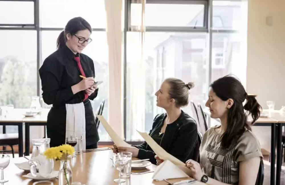 Hình ảnh phục vụ đang lấy order của khách hàng tại nhà hàng ở Đức 